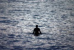 Waiting. The sun had already set, but this surfer just wo... by Mathew Cook 